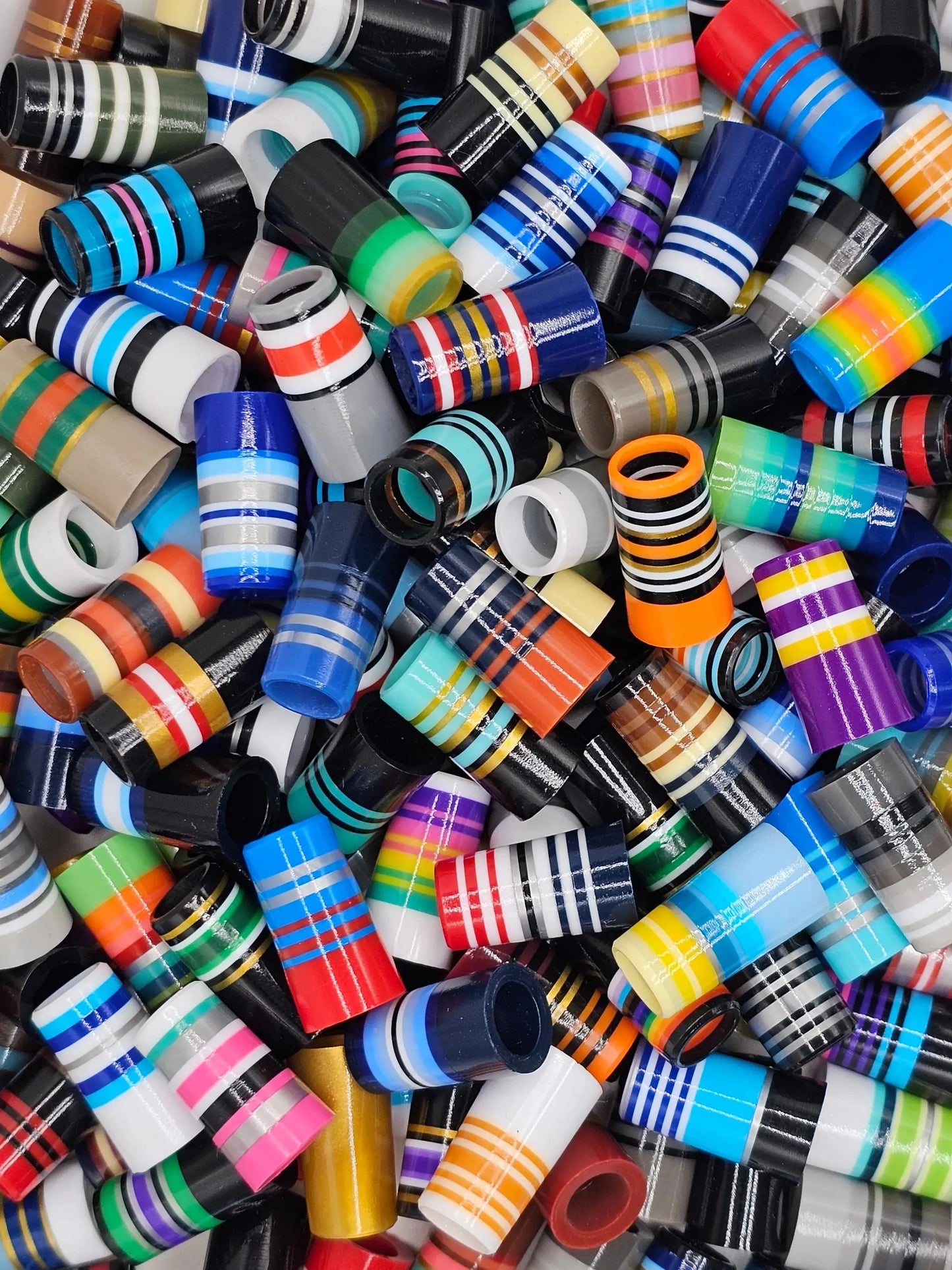Colorful assortment of Shorty Roulette ferrules by BBF, featuring striped designs for golf club customization in outdoor recreation gear.